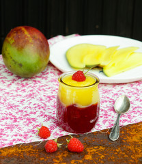 Mango and raspberry dessert in a glass jar