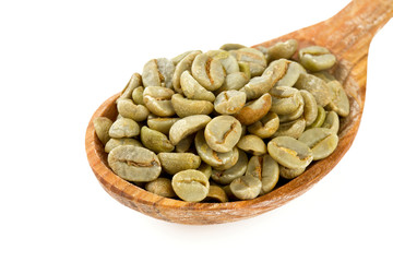 green coffee beans in a wooden spoon