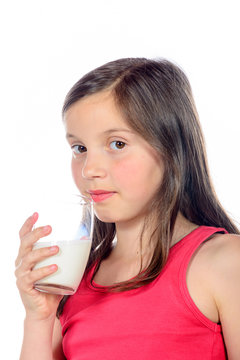 a little  girl is drinking a glass of milk