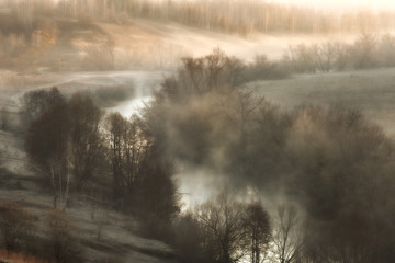 Surreal landscape with a river mist at sunrise