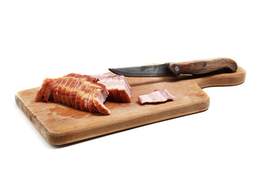 Bacon and the knife on the cutting board. Isolated on white