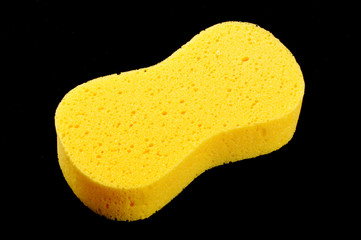 Yellow body care sponge isolated on the black background