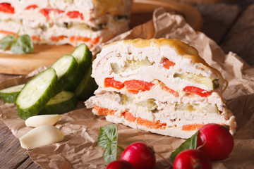 A piece of chicken pie with vegetables and cheese on paper