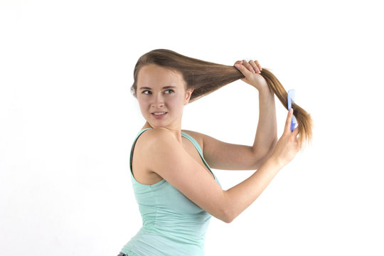 Young blonde woman combing hair
