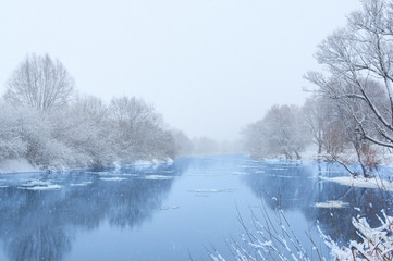 Obraz na płótnie Canvas Winter river in snowy weather