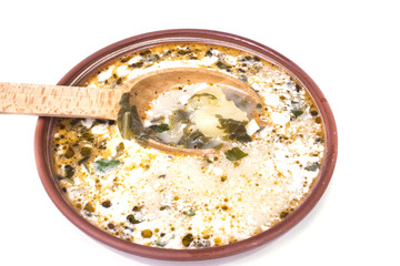 full plate with a spoon with green borscht with sour cream