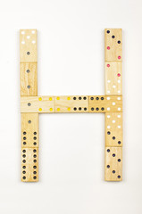 Alphabet letter H arranged from wood dominoes tiles isolated