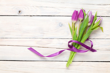 Fototapeta premium Purple tulips over wooden table