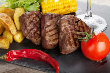 Steak with grilled potato, corn, salad and red wine