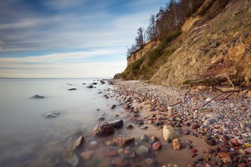 Cliff on sea shore at sunrise. Baltic sea long exposure photo