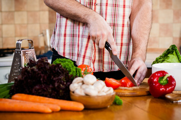 Man cuts fresh spring vegetables