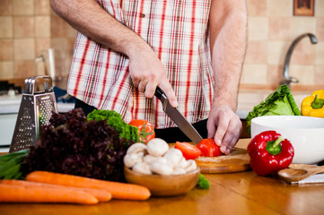 Man cuts fresh spring vegetables
