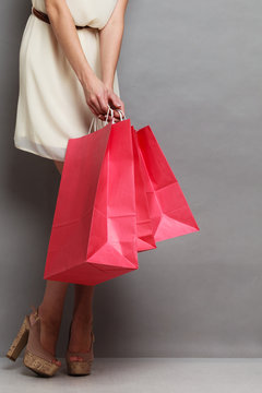 Woman holding red paper shopping bags