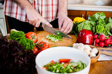Man cuts fresh spring vegetables