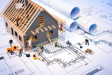 Fototapeta building house on blueprints with worker - construction project obraz