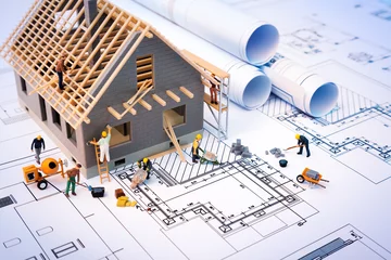Foto op Plexiglas building house on blueprints with worker - construction project © Romolo Tavani