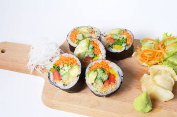 Set of vegetarian sushi rolls on a wooden plate isolated on whit