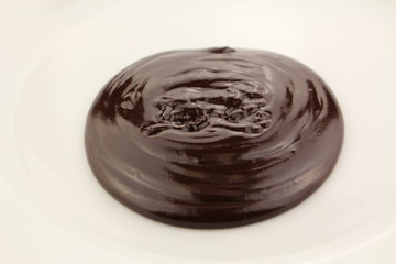 Melted semi-liquid bitter chocolate on a white plate