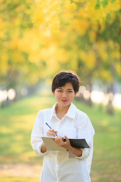 portrait of beautiful asian young woman staning in yellow flower