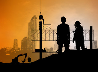 Fototapeta na wymiar silhouette engineer looking blueprint in a building site over Bl