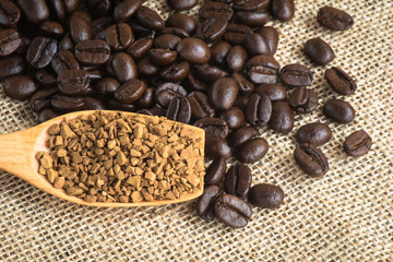 Close up granules coffee on wooden spoon and coffee bean
