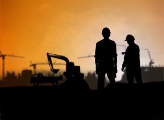silhouette engineer looking Loaders and trucks in a building sit
