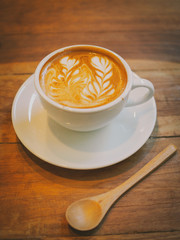 cup of coffee latte art on the wood desk
