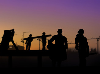 silhouette of architect looking at blueprints in a building site