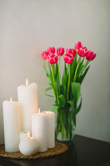 Bouquet of pink tulips with beautiful candles