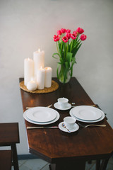   Decorated table with a beautiful bouquet of pink tulips with c