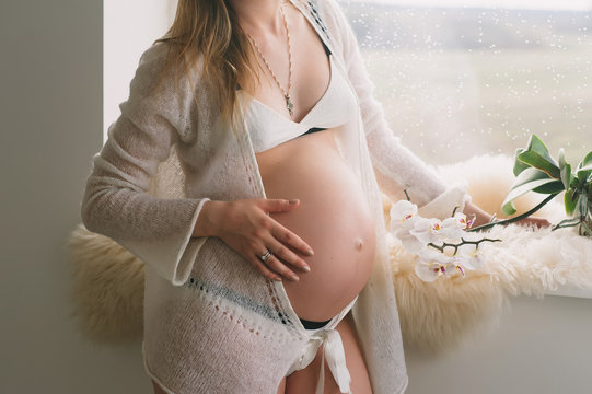 Beautiful young pregnant girl dressed in white, to be a parent