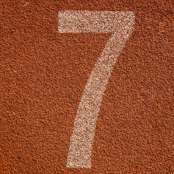 White track number on red rubber racetrack. textured running rac