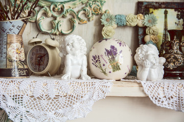 Vintage table with two angels, clocks and knitted cloth