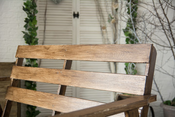 Naklejka premium Brown lacquered bench on the background of bright wall with tree