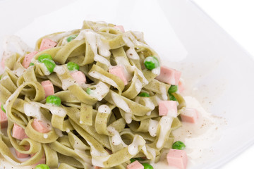 Pasta tagliatelle with green peas and ham.