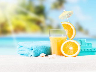     Fresh orange juice, fruits on sand with blue sky background