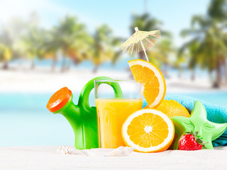     Fresh orange juice, fruits on sand with blue sky background
