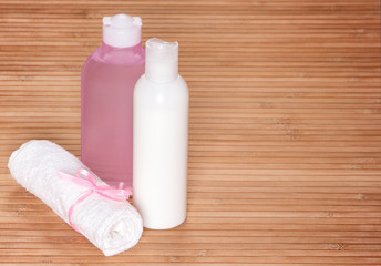 Cleansing face tonic and milk with a towel on wooden surface