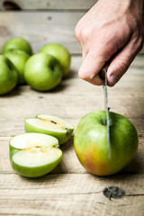 Hands of senior man cutting an apple