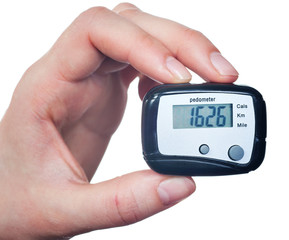 Close-up Of Hand  Holding Digital Pedometer On White Background