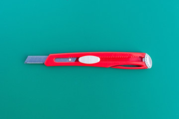 A ruler and cutter on green cutting mat