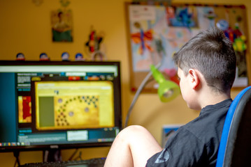 Fototapeta na wymiar Boy using computer at home, playing game