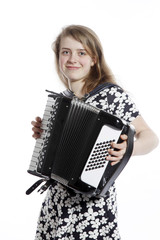 smiling teenage girl stands in studio with accordion