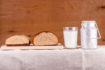 Cut loaf of fresh bread on burlap on wooden table