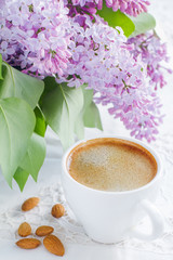 Obraz na płótnie Canvas Cup of coffee and spring flowers