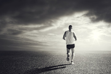 Sportive Man running very fast under sunset