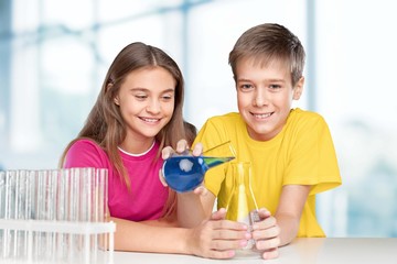 Project. Young school kids doing a chemistry experiment with the