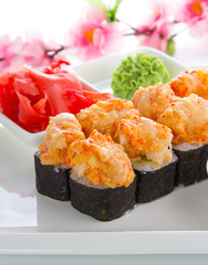 Spicy sushi roll with cinger and wasabi over white background
