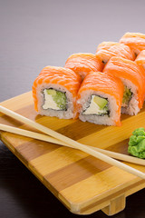 Salmon sushi roll on a wooden plate