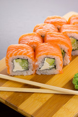 Salmon sushi roll on a wooden plate